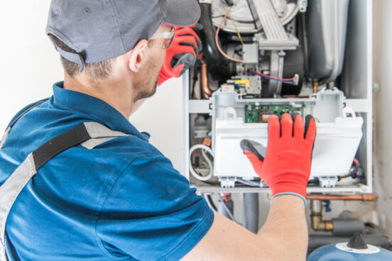 An R.D. Davis Heating & Air Conditioning technician works on a Furnace Repair Rochester IL