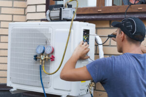 A team member of R.D. Davis Heating & Cooling, HVAC Contractors Sherman IL trusts, works on an outdoor unit