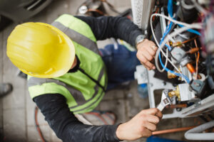 A tech from R.D. Davis Heating & Air Conditioning, which offers Air Conditioning Repair Sherman IL trusts, works on a unit