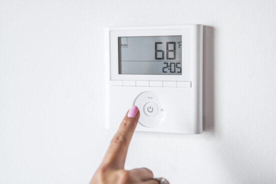 A homeowner in Chatham IL checks her thermostat