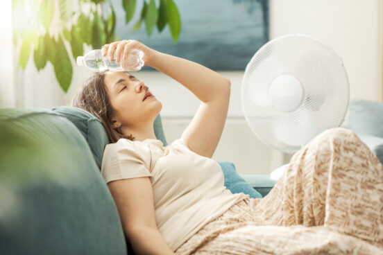 A woman in Rochester IL swelters on her couch while holding a cold water on her head