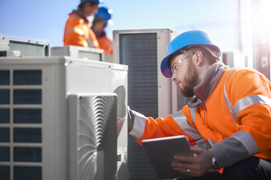 An air conditioning engineer is finishing the installation of several units on a rooftop after getting a call for Commercial AC Repair Springfield IL service